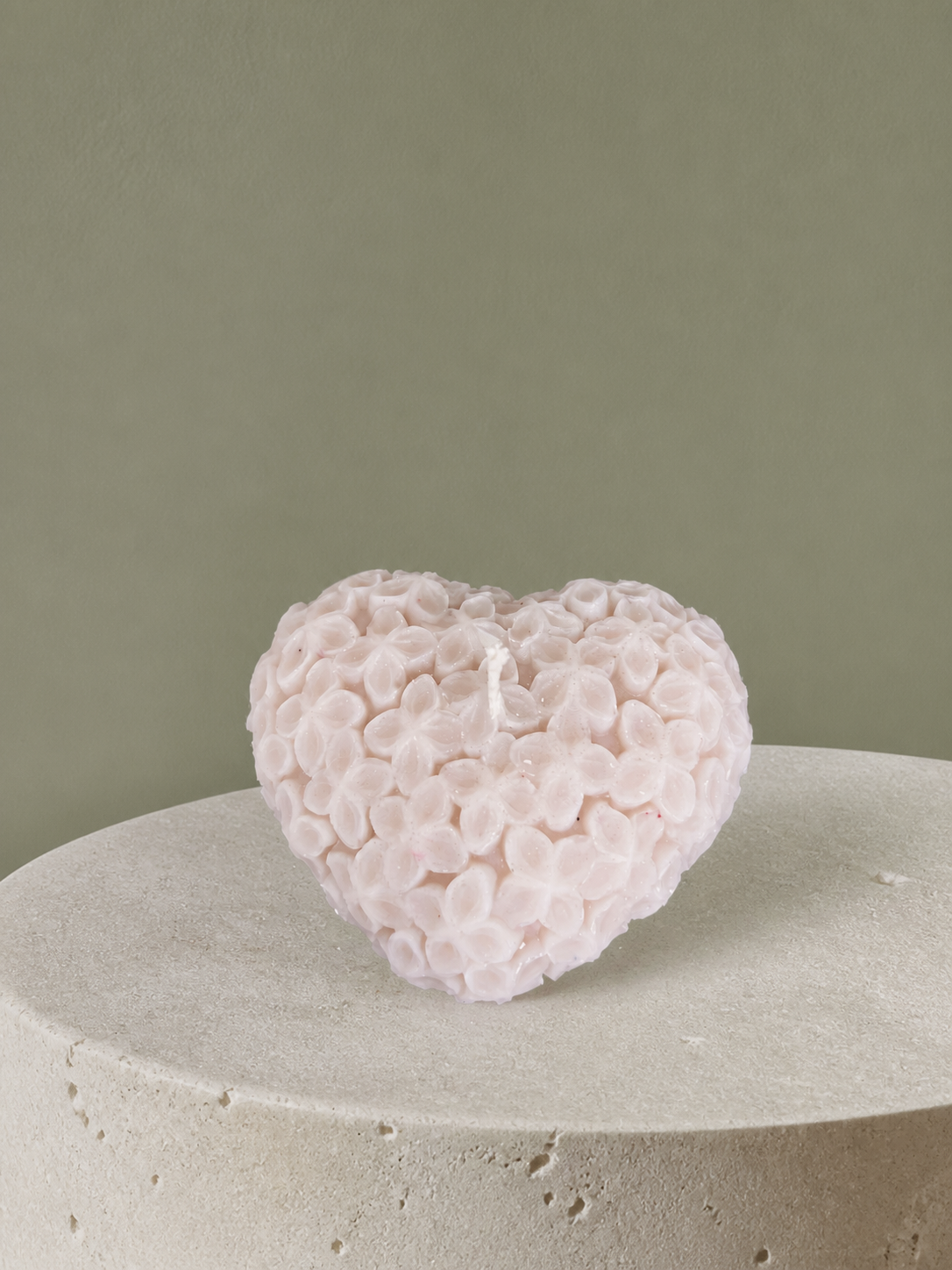 Blush heart-shaped sculptural candle embossed with delicate flowers