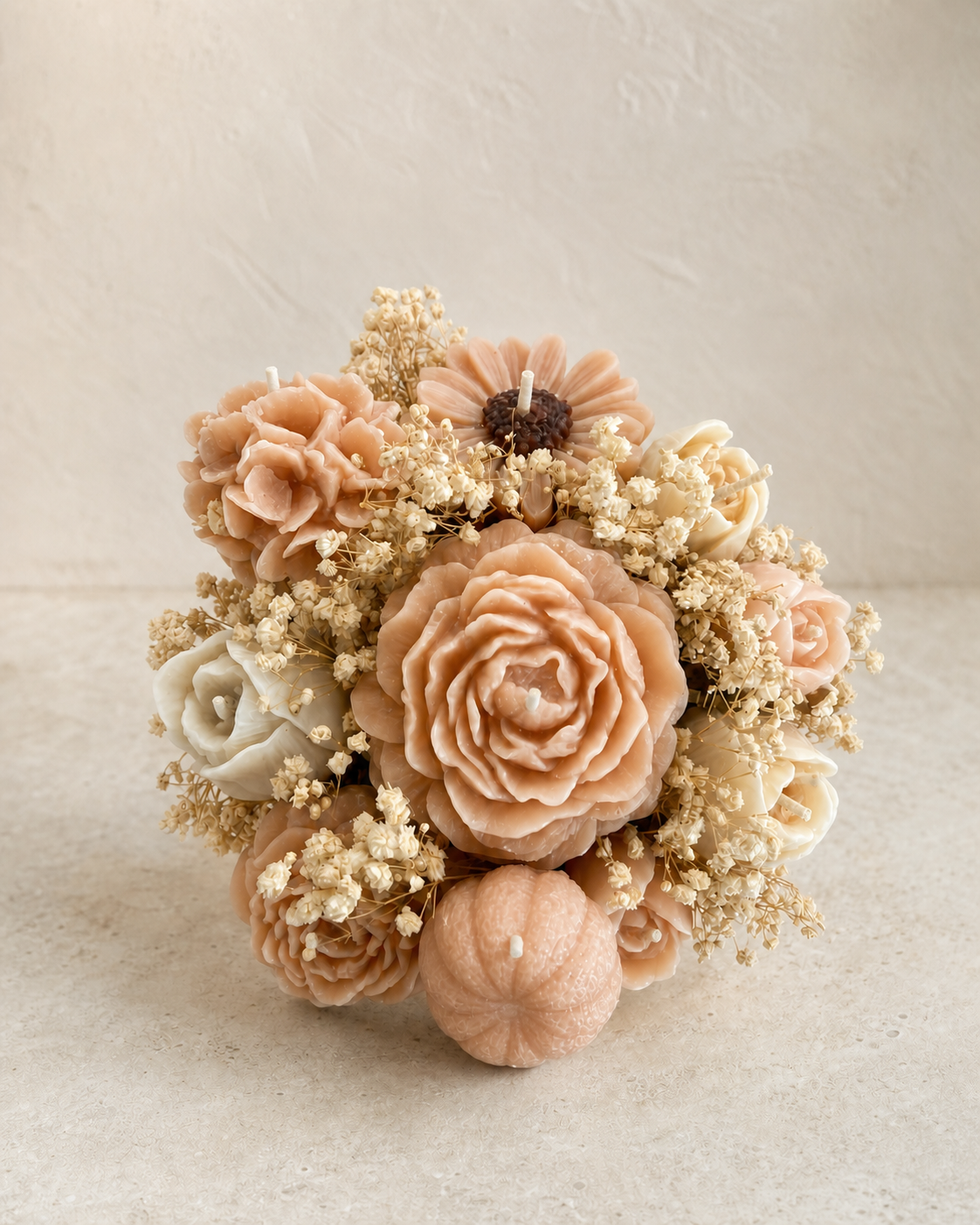 Close view of blush and ivory sculptural wax flowers in a candle bouquet