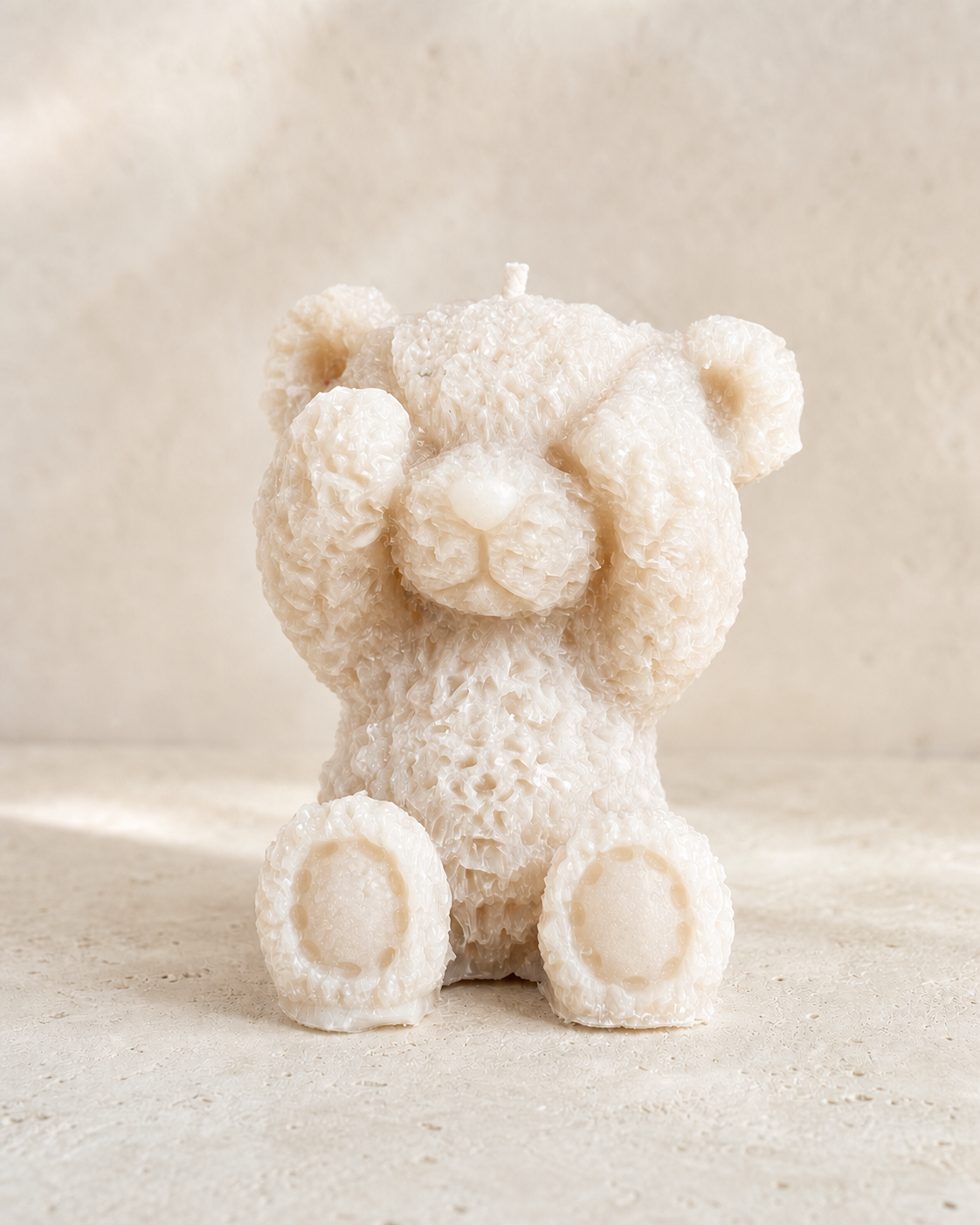 Ivory sculptural teddy bear candle with a softly textured wax finish
