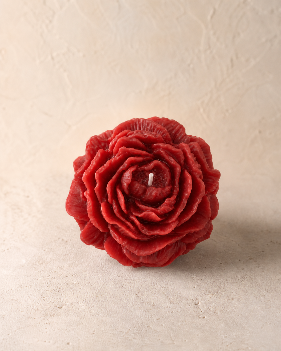 Crimson red sculptural peony candle with detailed layered petals