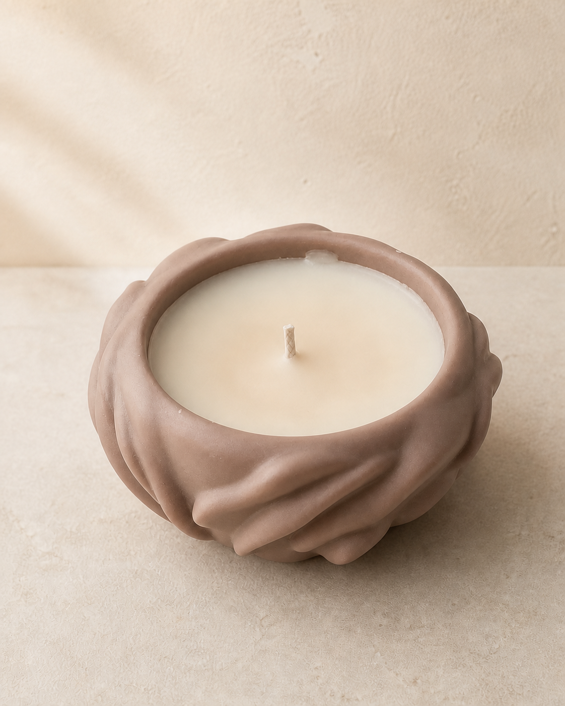 Taupe sculptural flower bowl filled with smooth ivory wax